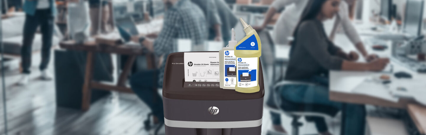 HP Aktenvernichter Öl 120 ml und 400 ml Flasche auf HP Pro Shredder mit Ölpapier und Großraumbüro im Hintergrund/GO Europe