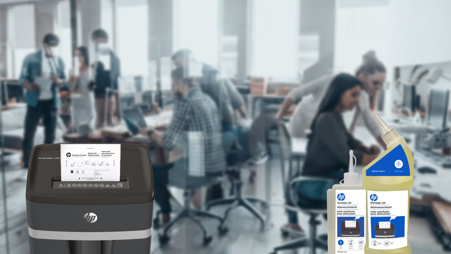 HP shredder oil 120 ml and 400 ml bottle and oil paper in Pro Shredder with open office in the background/GO Europe
